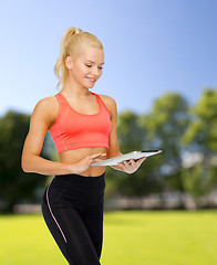 Image showing smiling sporty woman with tablet pc computer