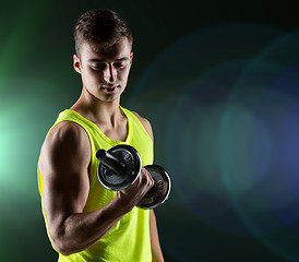 Image showing young man with dumbbell flexing biceps