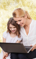 Image showing smiling mother and little girl with laptop