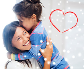 Image showing smiling little girl and mother hugging indoors