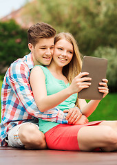 Image showing smiling couple with tablet pc making selfie