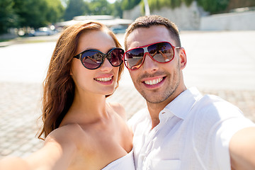 Image showing smiling couple wearing sunglasses making selfie