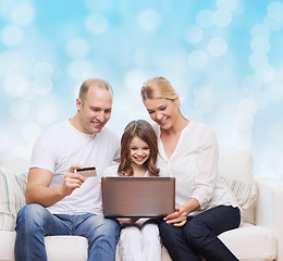 Image showing happy family with laptop computer and credit card