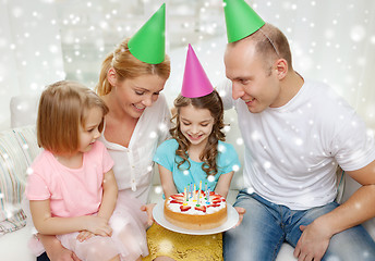 Image showing happy family with two kids in party hats at home