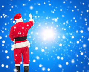 Image showing man in costume of santa claus writing something