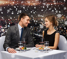 Image showing smiling couple eating main course at restaurant