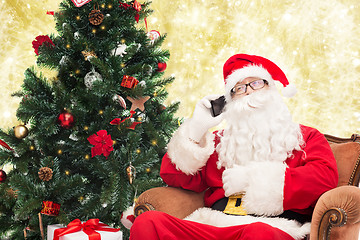 Image showing santa claus with smartphone and christmas tree