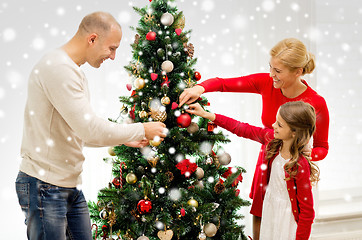 Image showing smiling family decorating christmas tree at home