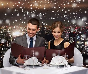 Image showing smiling couple with menus at restaurant