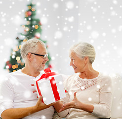 Image showing happy senior couple with gift box at home