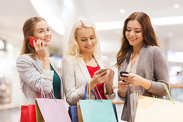 Image showing happy women with smartphones and shopping bags