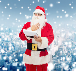 Image showing man in costume of santa claus with notepad