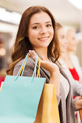 Image showing happy young women with shopping bags in mall