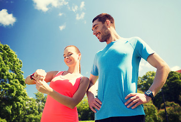 Image showing smiling people with heart rate watches outdoors