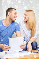 Image showing happy couple with papers and calculator at home