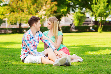 Image showing smiling couple sitting on grass in park