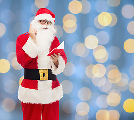 Image showing man in costume of santa claus with notepad