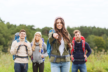 Image showing smiling hikers with backpacks pointing finger