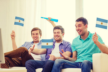 Image showing happy male friends with flags and vuvuzela