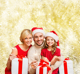 Image showing happy family in santa helper hats with gift boxes