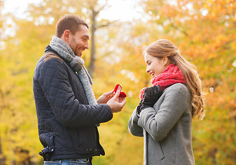 Image showing smiling couple with engagement ring in gift box