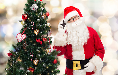 Image showing santa claus with smartphone and christmas tree