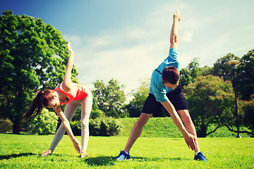 Image showing smiling couple stretching outdoors