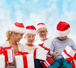 Image showing happy family in santa helper hats with gift boxes