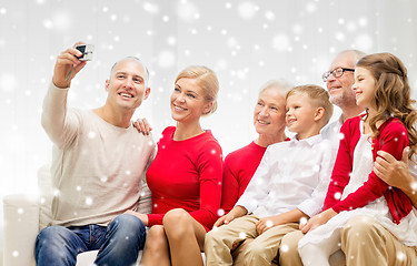 Image showing smiling family with camera at home