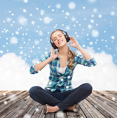 Image showing young woman in headphones listening to music