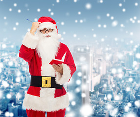 Image showing man in costume of santa claus with notepad