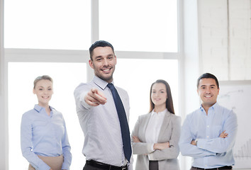 Image showing businessman in office pointing finger at you