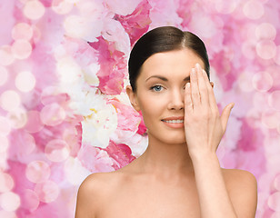 Image showing smiling young woman covering face with hand