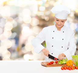 Image showing smiling female chef chopping vegetables