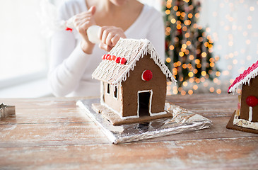 Image showing close up of woman making gingerbread houses