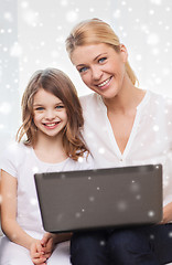 Image showing smiling mother and little girl with laptop at home