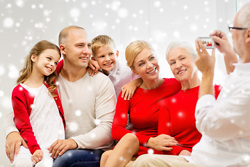 Image showing smiling family with camera photographing at home