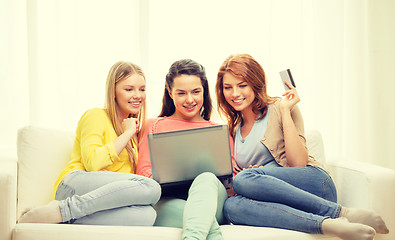 Image showing smiling teenage girls with laptop and credit card