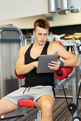 Image showing young man with tablet pc computer in gym