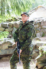 Image showing young soldier or hunter with gun in forest