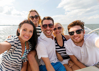 Image showing smiling friends sitting on yacht deck