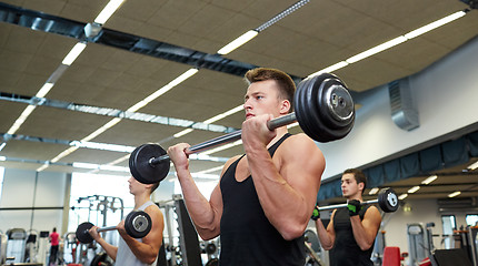Image showing group of men flexing muscles with barbell in gym
