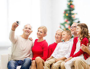 Image showing smiling family with camera at home