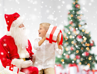 Image showing smiling little boy with santa claus and gifts