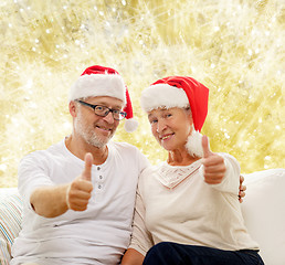 Image showing happy senior couple in santa helper hats