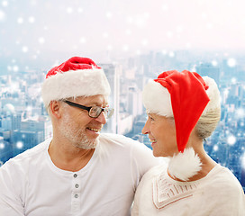 Image showing happy senior couple in santa helper hats