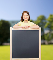 Image showing happy little girl with blank blackboard