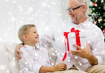 Image showing smiling grandfather and grandson with gift box