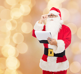 Image showing man in costume of santa claus with notepad