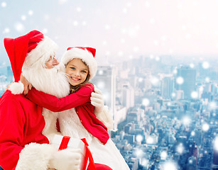 Image showing smiling little girl with santa claus and gifts